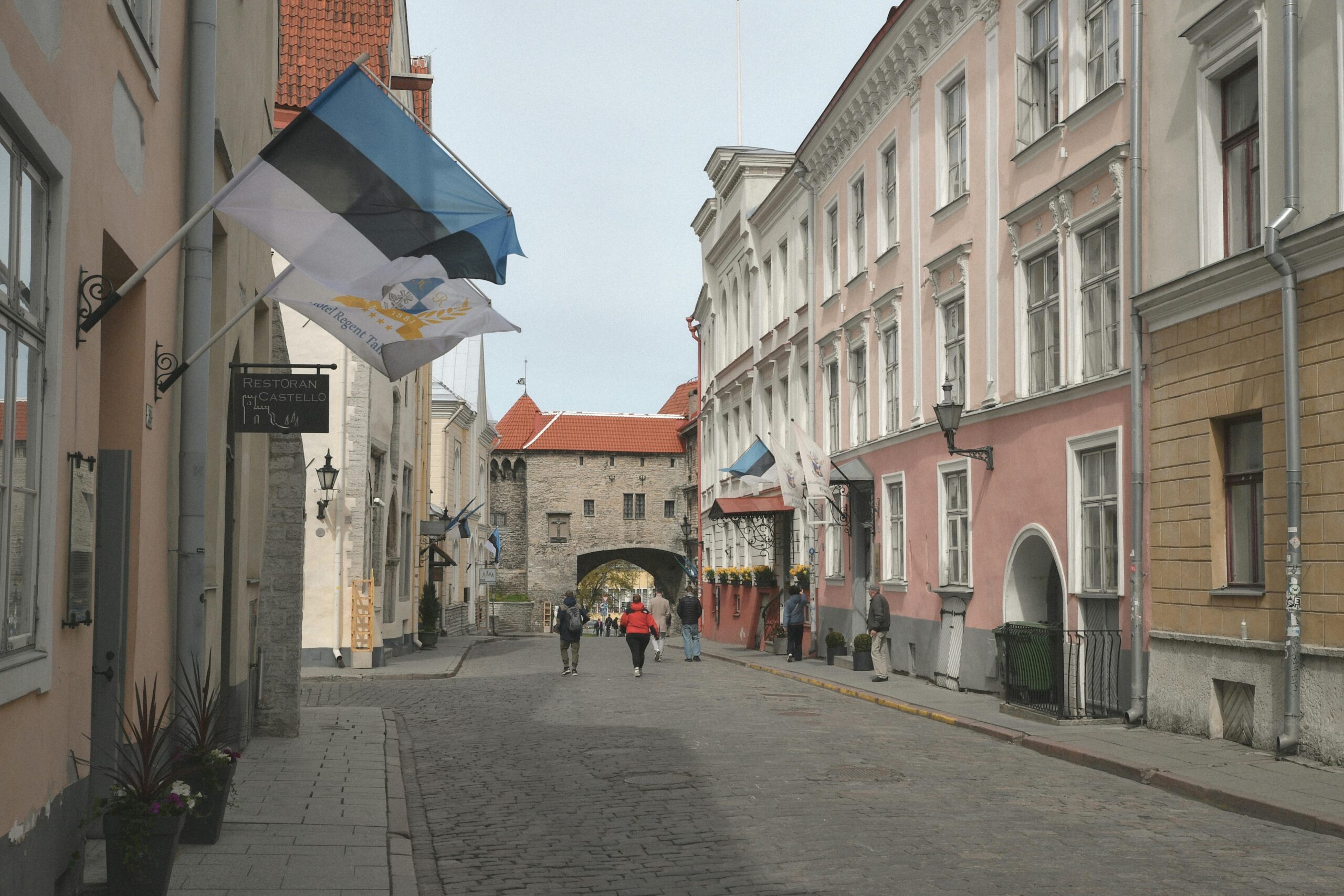View of a historic Tallinn street featuring pastel houses and Fat Margaret's Gate.