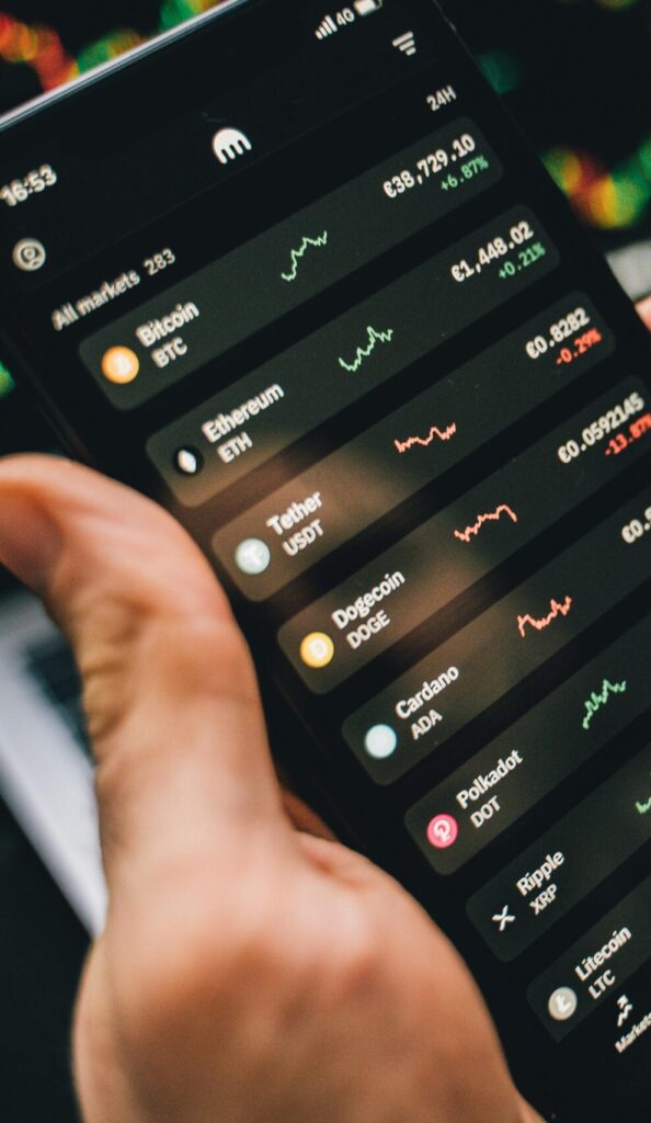 Person holding smartphone showing cryptocurrency market data, symbolizing digital investment tools.