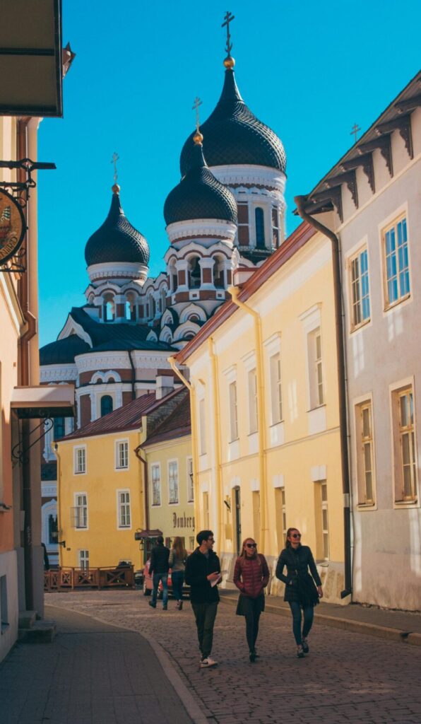 Charming street in Tallinn, Estonia with view of Alexander Nevsky Cathedral under clear blue skies.