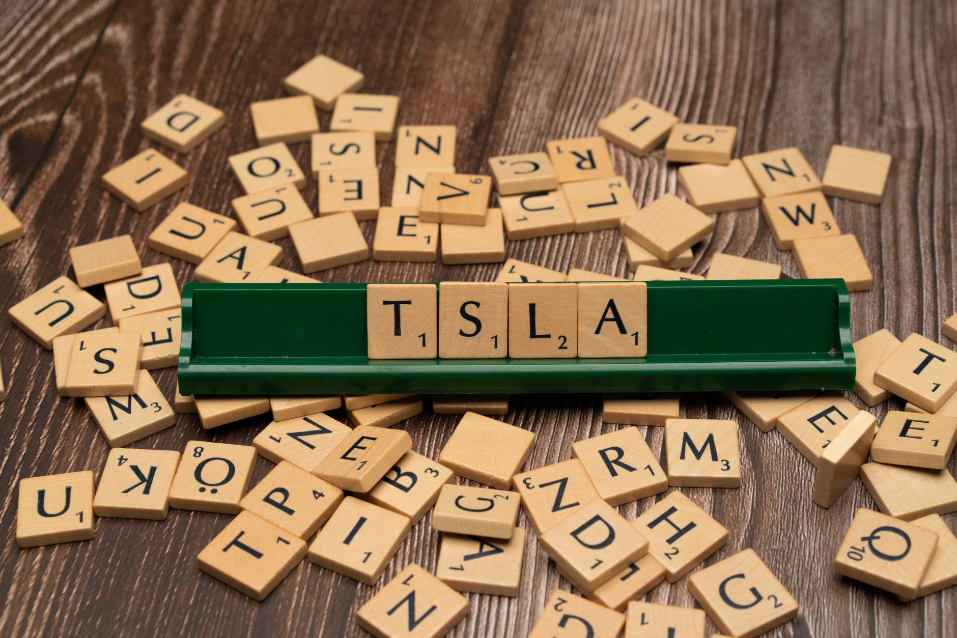 the word tsla is spelled out in scrabble tiles