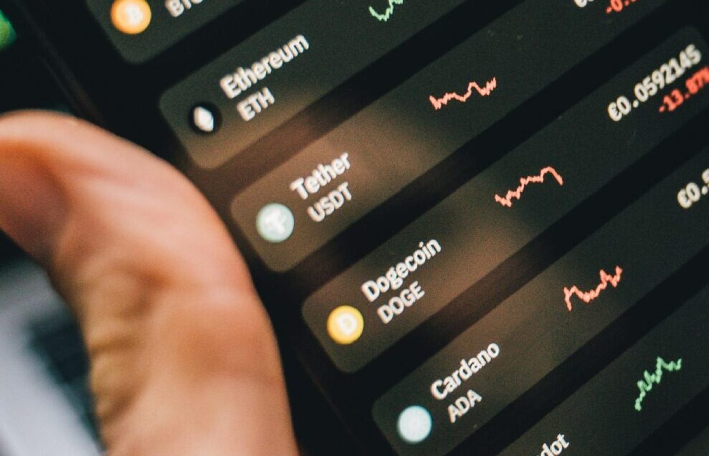 Person holding smartphone showing cryptocurrency market data, symbolizing digital investment tools.